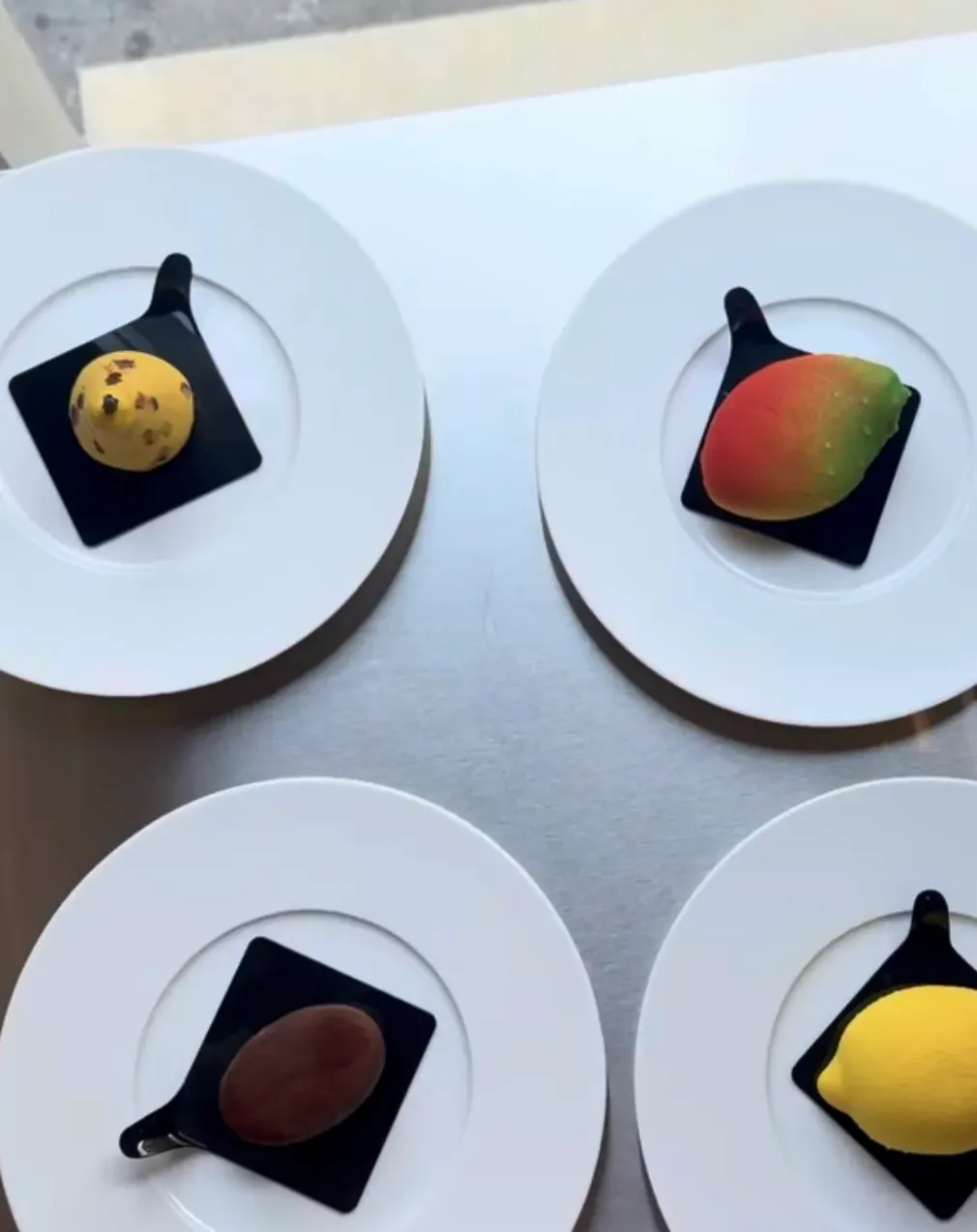 Monoporzioni moderne a forma di frutta su piatti — pasticceria Firenze